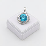 swiss blue topaz round stone 29.50ct Silver pendant with a blue gemstone on a white box