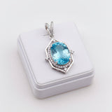 swiss blue topaz round stone 43.70ct Blue gemstone pendant on a white cushioned stand