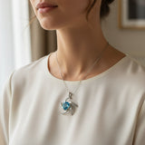 swiss blue topaz trillion 31.60ct Woman wearing a necklace with a blue gemstone pendant