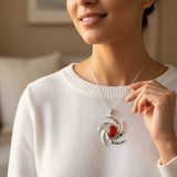 natural red agate carnelian aqeeq 28.00ct Woman wearing a white sweater with a silver necklace featuring a red pendant.