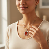 natural red agate carnelian aqeeq 31.15ct Woman wearing a necklace with a red pendant, indoors.