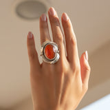 natural red agate carnelian aqeeq 33.65ct Hand wearing a silver ring with a red stone against a neutral background