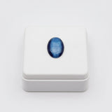 cat eye stone 58.40ct Blue oval stone in a white box on a light gray background