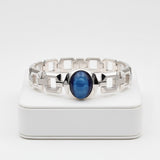 cats eye stone 57.35ct Silver bracelet with a blue stone on a white background