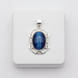 cats eye stone 57.35ct Silver pendant with a blue stone on a white background