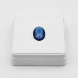 cat eye 59.50 ct Blue oval gemstone on a white background