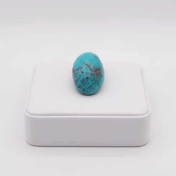 nishapur terquoise 41.10ct stone on a white box with a white background