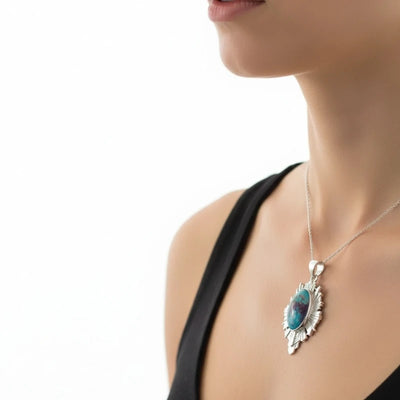 nishapur turquoise 33.90ct Necklace with a turquoise pendant worn by a person on a white background