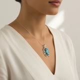 nishapur turquoise 74.90ct Necklace with a turquoise pendant worn by a person in a white dress.