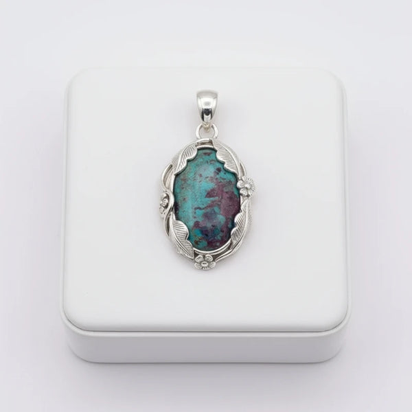 nishapur turquoise 41.70ct Silver pendant with a green and purple stone on a white background