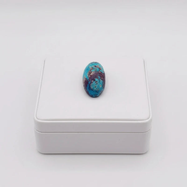 nishapur turquoise 33.90ct stone on a white box against a white background