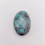 nishapur turquoise 74.90ct stone with brown speckles on a white background