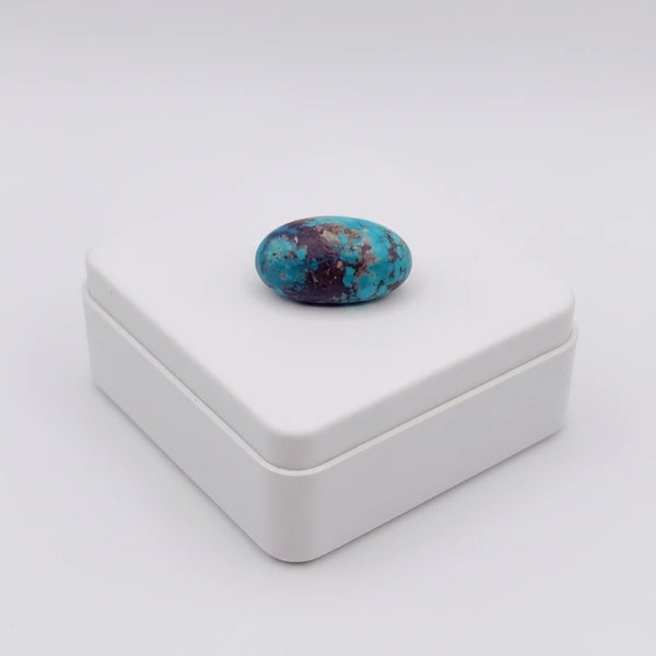 nishapur turquoise 33.90ct stone on a white square box against a white background