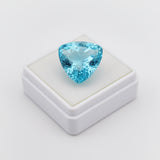 swiss blue topaz round stone 29.20ct Trillion-cut blue gemstone on a white stand with a light gray background