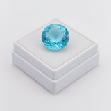 swiss blue topaz round stone 29.50ct Blue gemstone on a white box with a light gray background