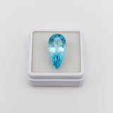 swiss blue topaz round stone 33.75ct Teardrop-shaped blue gemstone in a white box on a light gray background