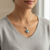 swiss blue topaz round stone 29.20ct Necklace with a blue gemstone pendant worn by a person in a gray sweater.