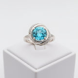 swiss blue topaz round stone 29.50ct Silver ring with a blue gemstone on a white background