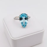 swiss blue topaz round stone 33.75ct  Ring with a large blue gemstone on a white stand
