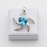 swiss blue topaz trillion 31.60ct Silver pendant with a blue gemstone on a white box