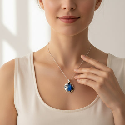 cat eye stone 58.40ct Woman wearing a necklace with a blue pendant against a neutral background