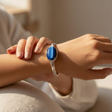 Close-up of a hand wearing a silver bracelet with a cat eye stone 61.00ct