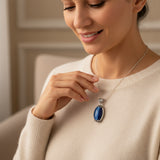 Woman wearing a cat eye 61.00ct necklace with a blue pendant, smiling 