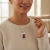 natural red agate carnelian aqeeq 37.10ct Woman wearing a silver necklace with a red stone pendant indoors