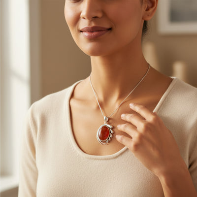 natural red agate carnelian aqeeq 31.15ct Woman wearing a necklace with a red pendant, indoors.