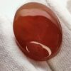 polished reddish-orange Carnelian gemstones, also known as Irani Aqeeq or Yemeni Haqeeq, displayed on a white background, showcasing their smooth cabochon cuts and vibrant natural color.