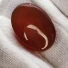 polished reddish-orange Carnelian gemstones, also known as Irani Aqeeq or Yemeni Haqeeq, displayed on a white background, showcasing their smooth cabochon cuts and vibrant natural color.