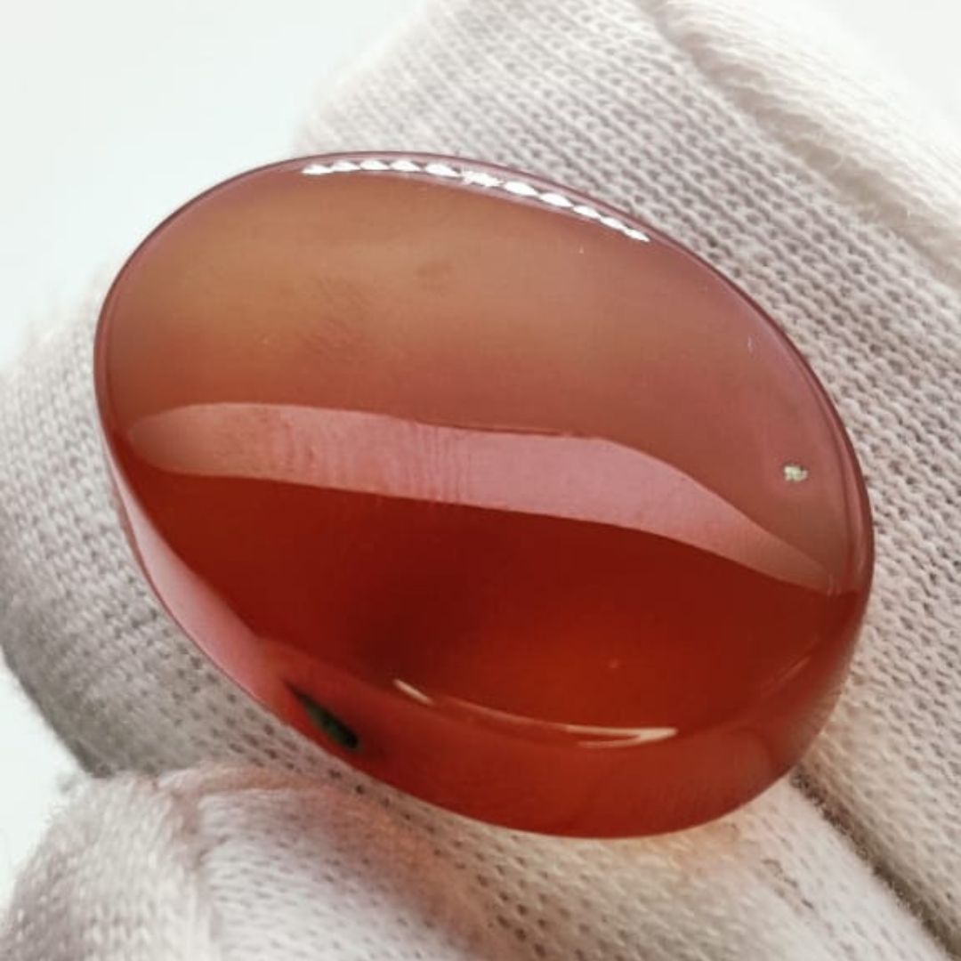 polished reddish-orange Carnelian gemstones, also known as Irani Aqeeq or Yemeni Haqeeq, displayed on a white background, showcasing their smooth cabochon cuts and vibrant natural color.